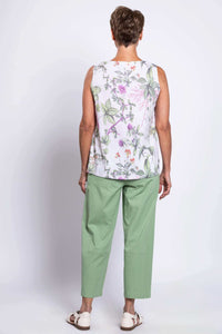 Back view of older woman in floral botanical tank top and green pants