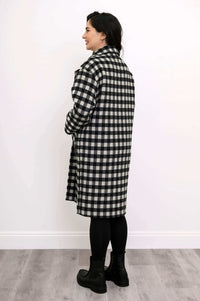 Back side view of model wearing mid-length black and white check coat