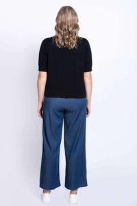 Back view of woman showing black short-sleeve cardigan and blue pants