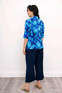 Back view of model wearing Lorine blue blouse with navy wide-leg pants