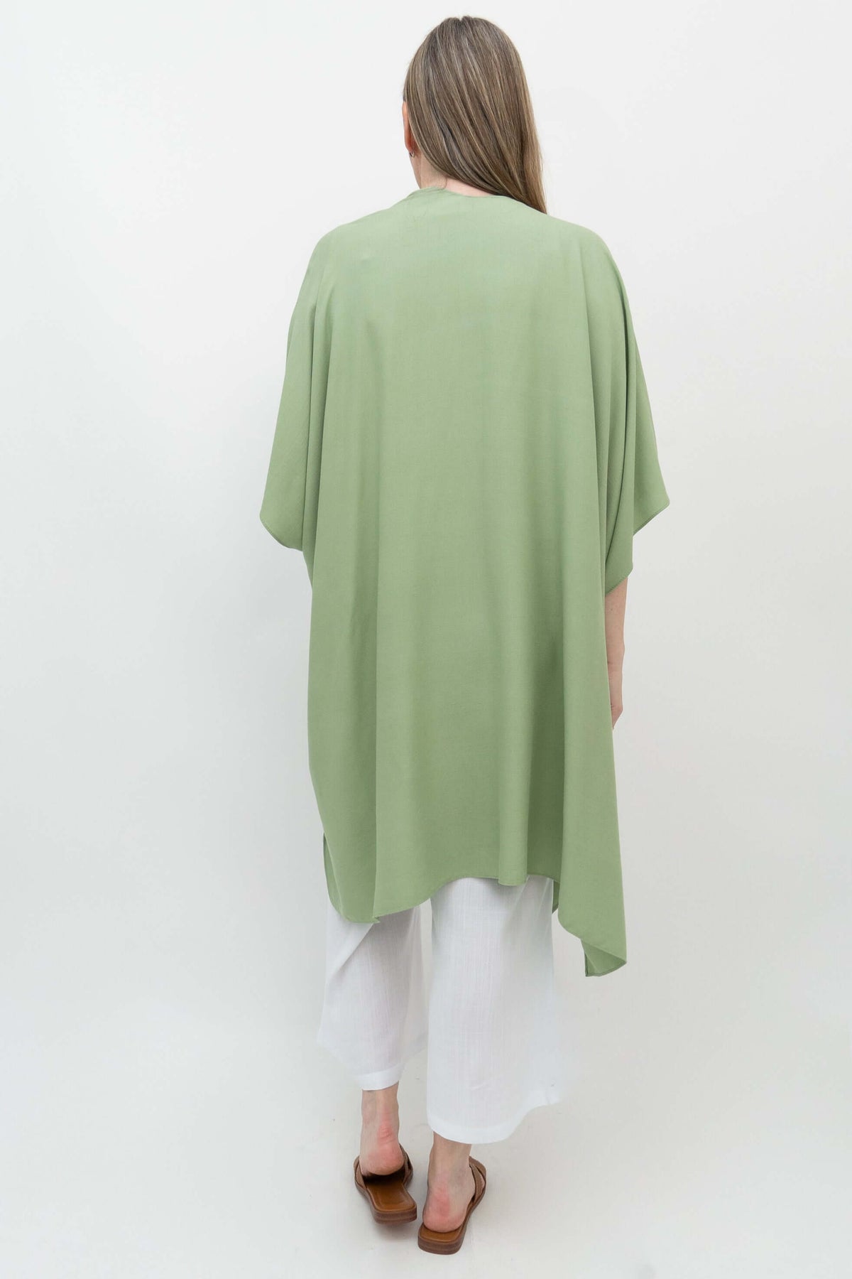 Back view of sage green kimono wrap draped over woman in white outfit