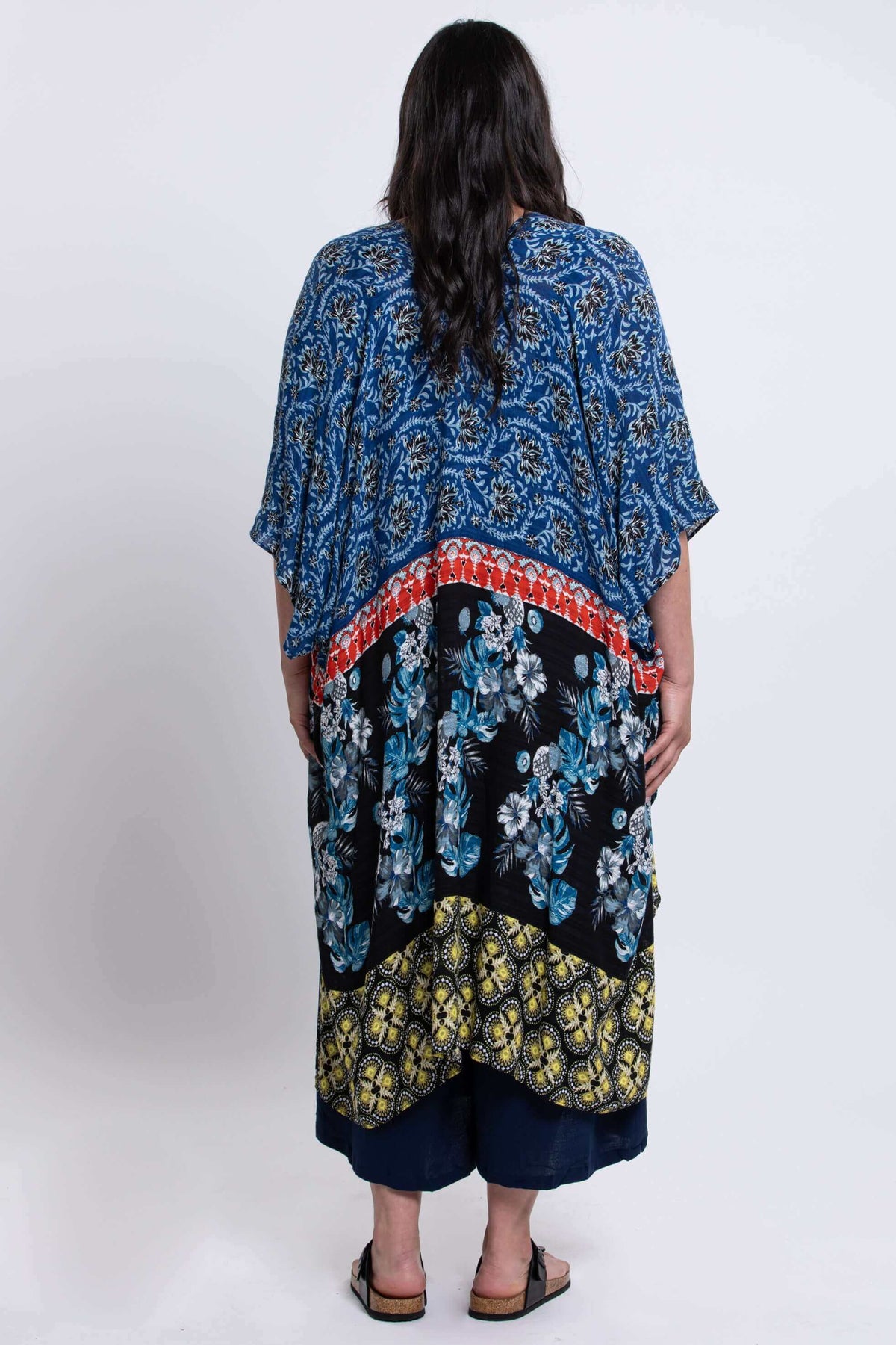 Back view of woman displaying the Darcy kimono wrap's blue and floral patterned fabric