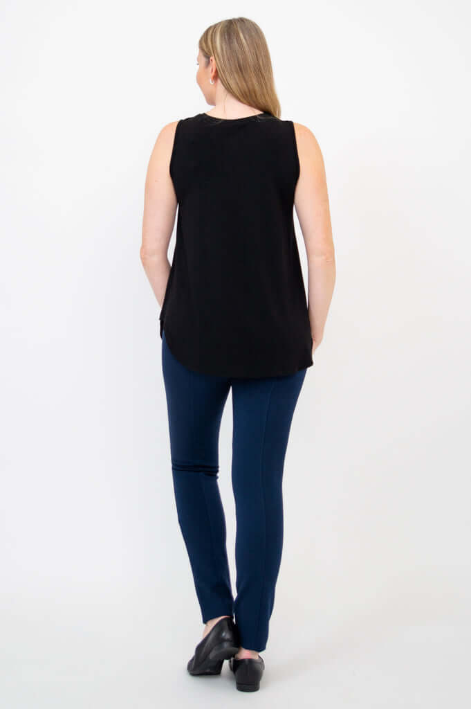 Back view of woman wearing black tank top and blue pants