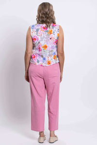 Back view of woman in a floral cropped tank with pink pants and beige shoes