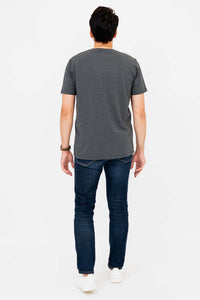 Back view of man wearing dark grey V-neck T-shirt and jeans