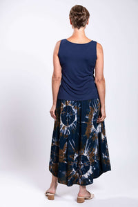 Back view of model wearing navy top and tie dye batik midi skirt, showing skirt's fit