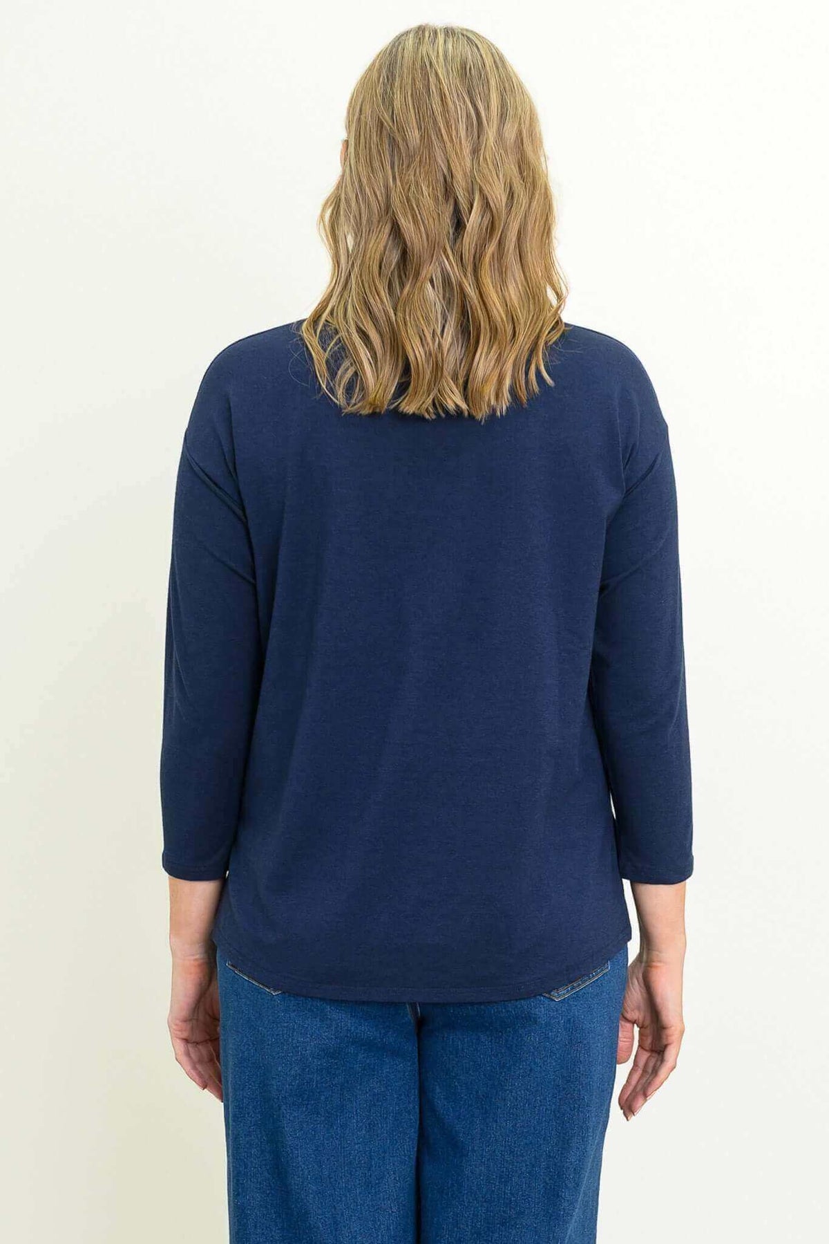 Back view of woman wearing a navy mock neck bamboo top