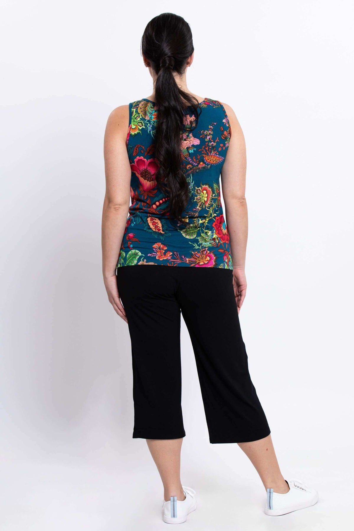 Back view of woman in floral bamboo tank top with black pants