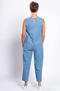 Back view of woman in blue sleeveless top with keyhole detail and cropped blue pants