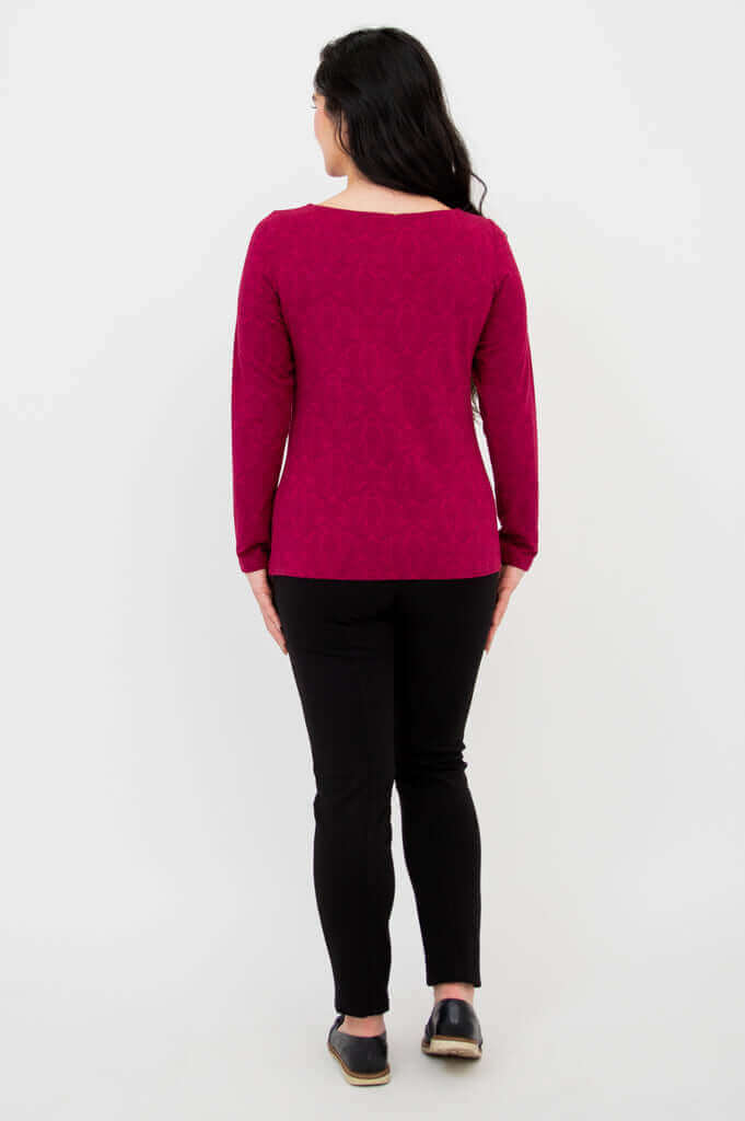 Back view of berry-colored long sleeve top paired with black pants