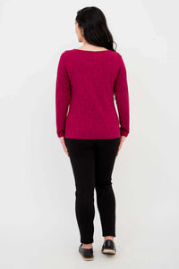 Back view of berry-colored long sleeve top paired with black pants