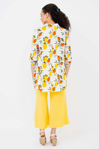 Back view of model in citrus print tunic and yellow wide-leg pants