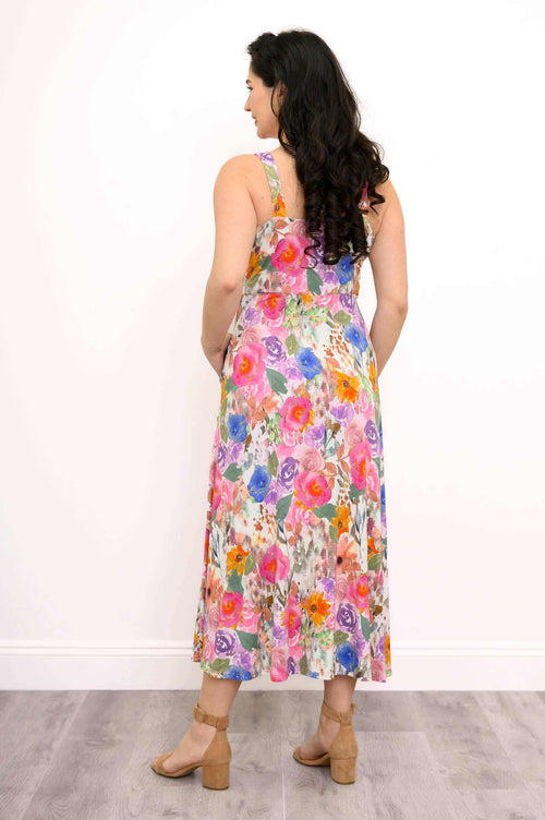 Back view of a woman in a vibrant floral maxi dress with fitted bodice