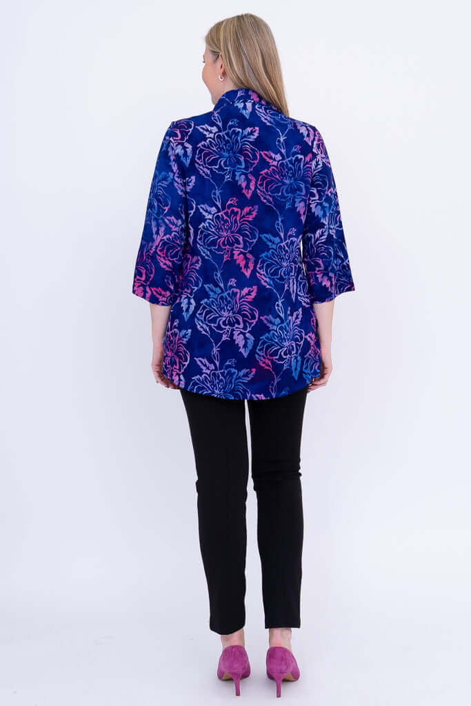 Back view of woman wearing blue and purple floral tunic with 3/4 sleeves