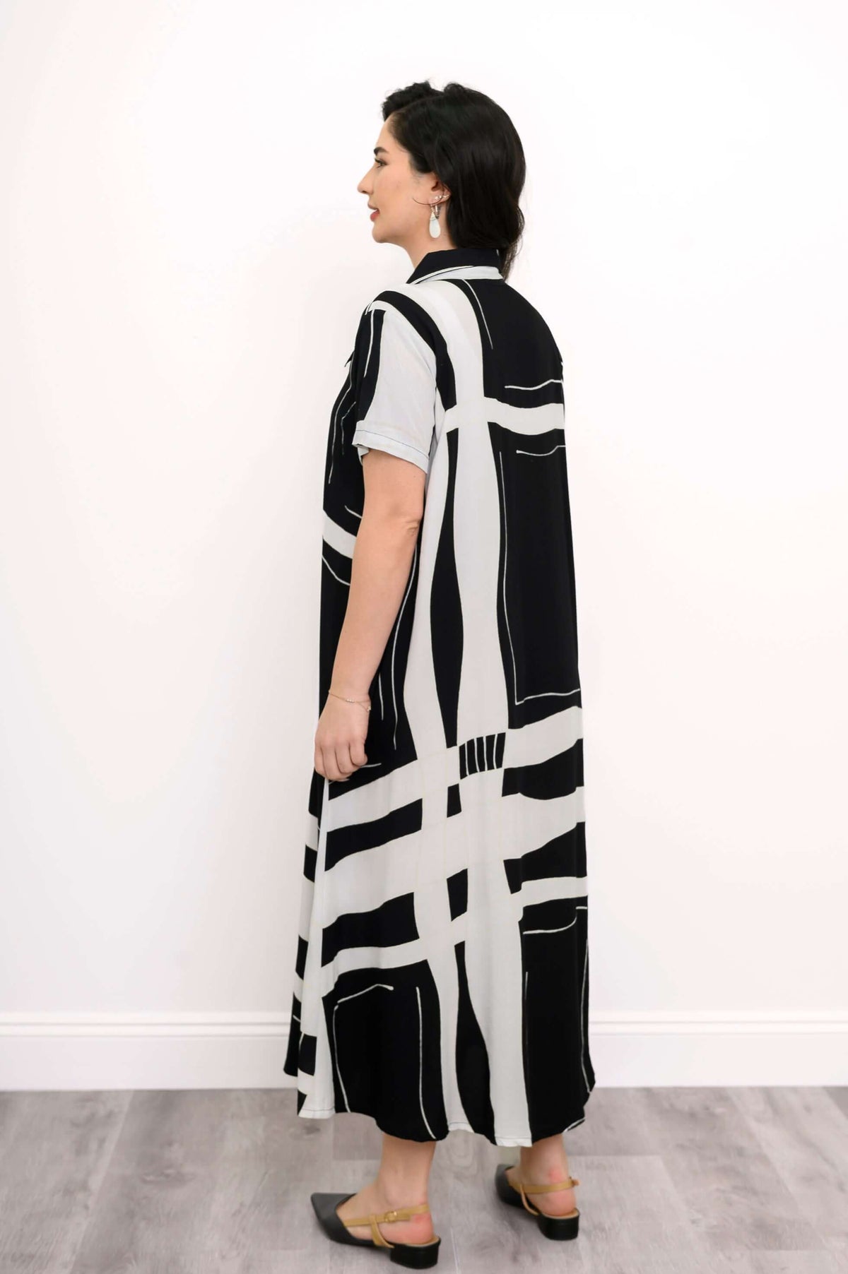 Back view of woman in black and white abstract print button-up A-line dress