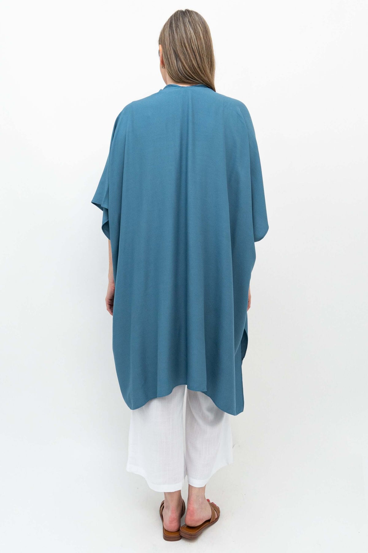 Back view of woman wearing ocean blue Darcy kimono wrap and white pants