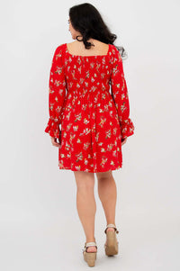 Back view of a model wearing a red ditsy print dress with a gathered bodice