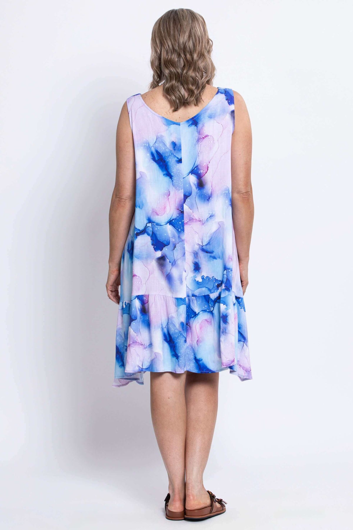Back view of woman showcasing ruffle detail on watercolor linen bamboo dress