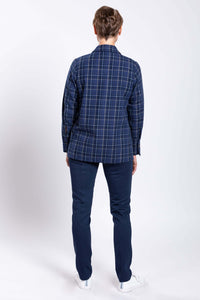 Back view of a woman in a blue plaid cotton jacket and navy pants