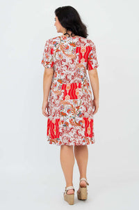 Model showing the back of a red and white floral empire waist dress with flutter sleeves