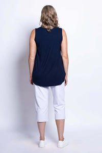 Back view of woman in navy bamboo tank top and white cropped pants