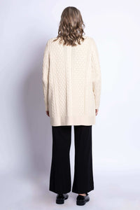 Back view of a woman wearing a cream cable knit long cardigan