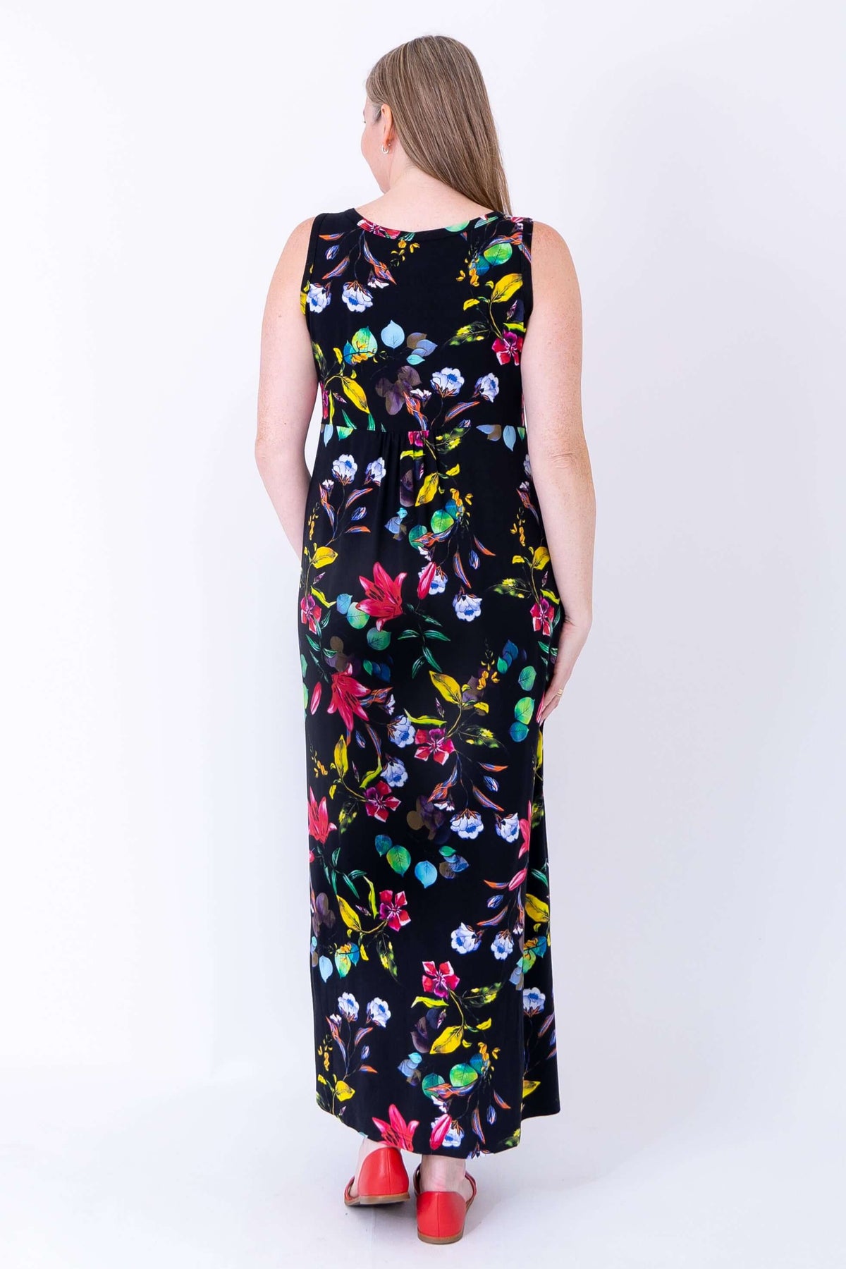 Back view of woman in sleeveless black bamboo maxi dress with colorful floral pattern