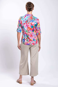 Back view of woman highlighting the floral bamboo linen blouse and neutral pants