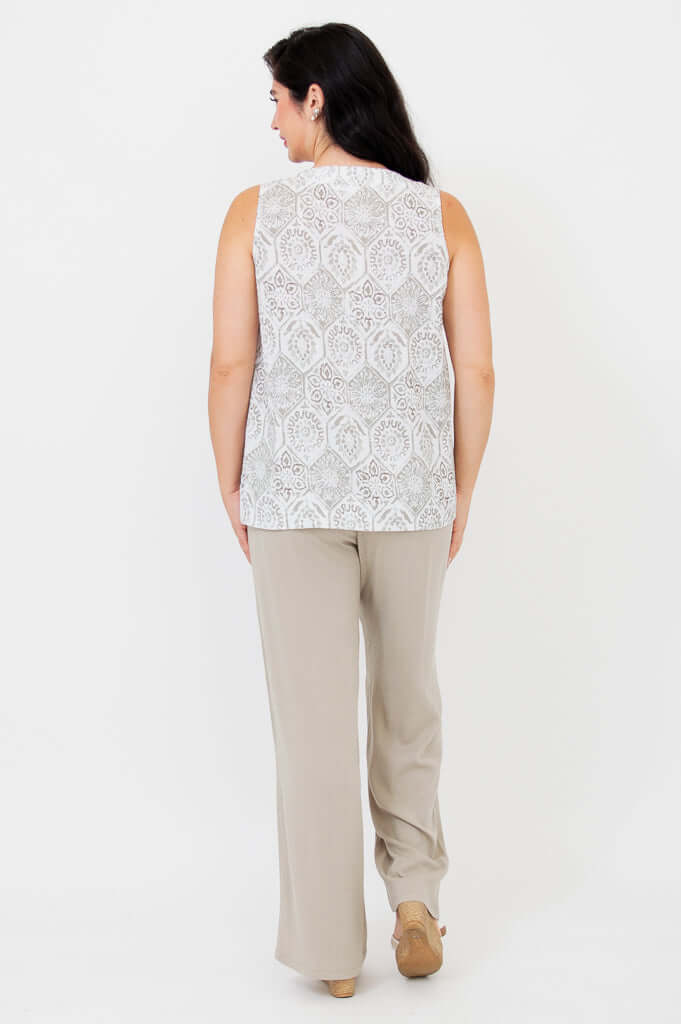 Back view of woman in sleeveless patterned tank and beige trousers