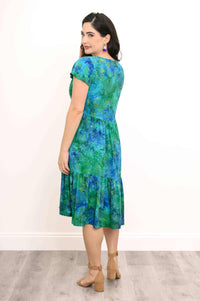 Back view of woman wearing a green and blue floral tiered midi dress