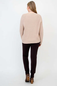 Back view of woman wearing beige knit Davis Sweater and brown pants