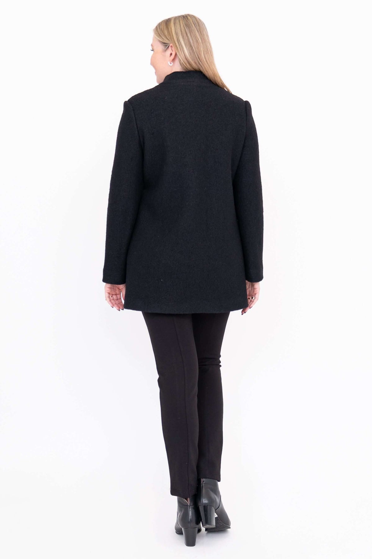 Back view of black boiled wool coat worn by woman with black pants