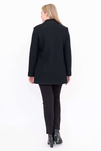 Back view of black boiled wool coat worn by woman with black pants