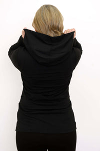 Back view of woman holding the hood of a black hoodie jacket