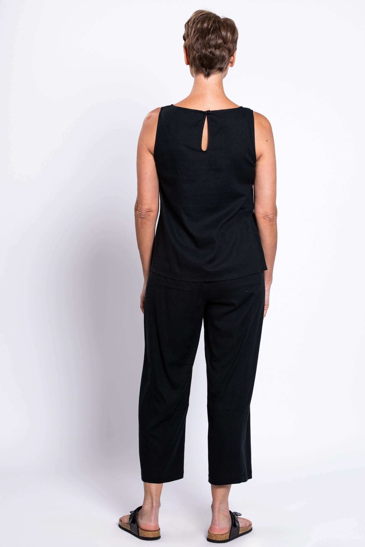 Back view of woman showcasing the button closure on black tank top