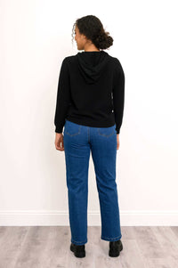 Back view of woman in black hoodie and blue jeans