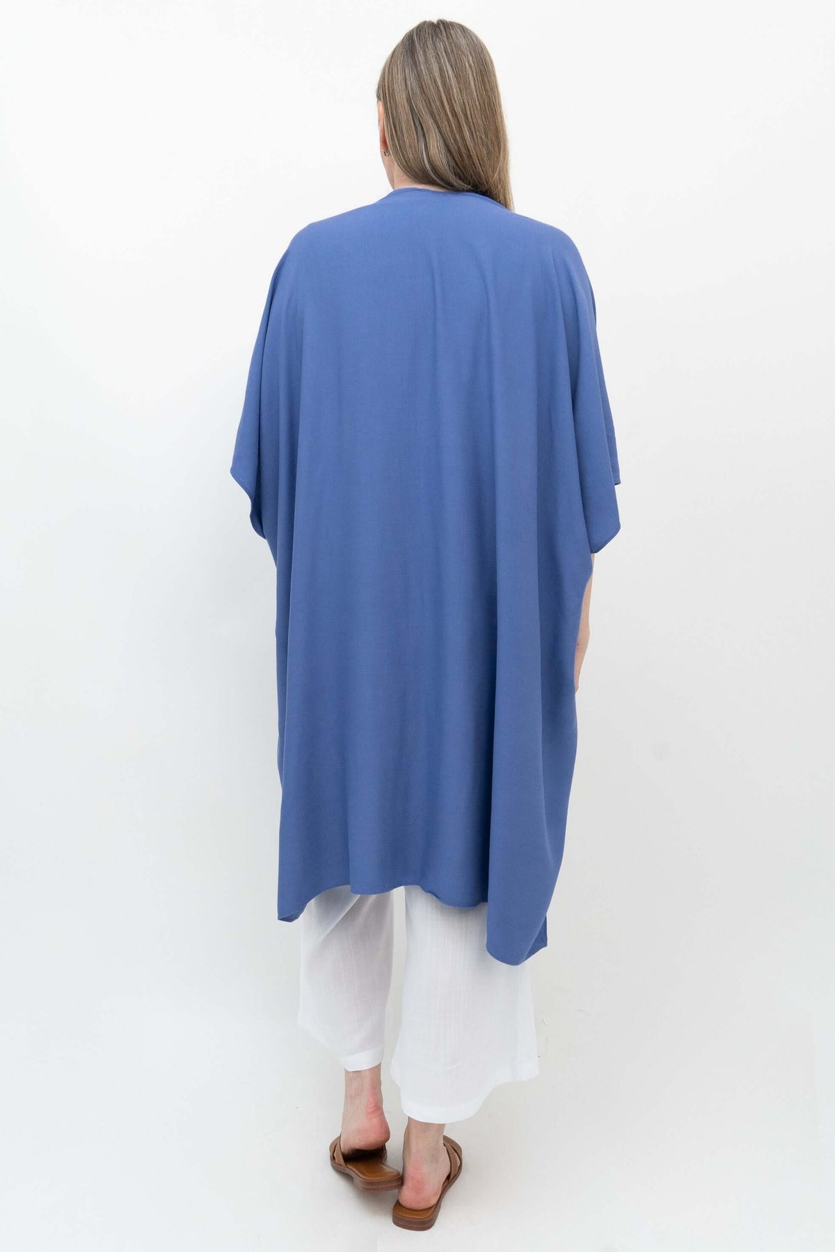Back view of blue Darcy Kimono Wrap on woman in white pants
