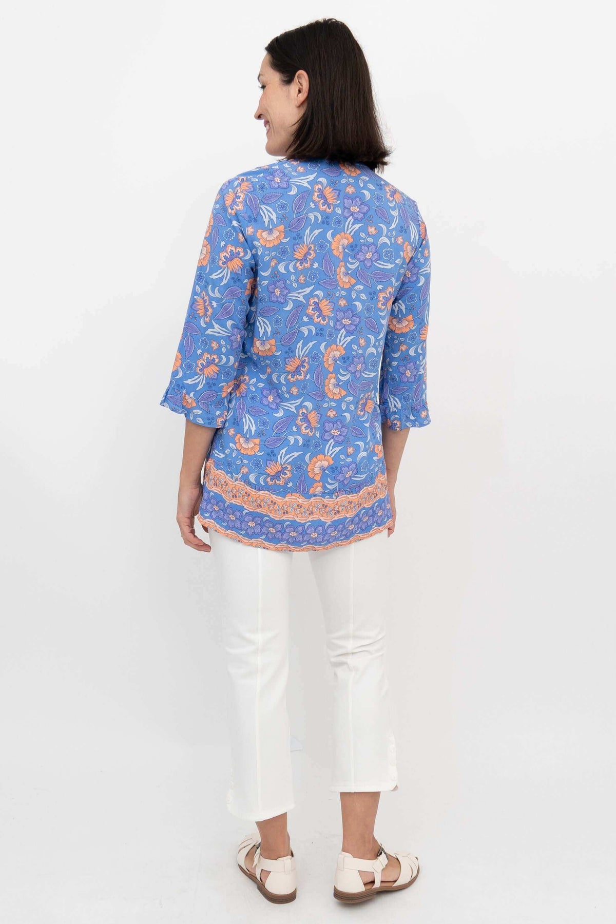 Back view of a woman wearing a blue and orange floral blouse