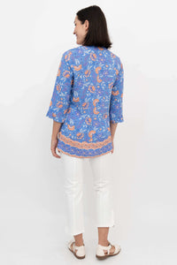 Back view of a woman wearing a blue and orange floral blouse