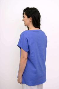 Back view of woman in a blue boatneck tee with casual fit and dolman sleeves