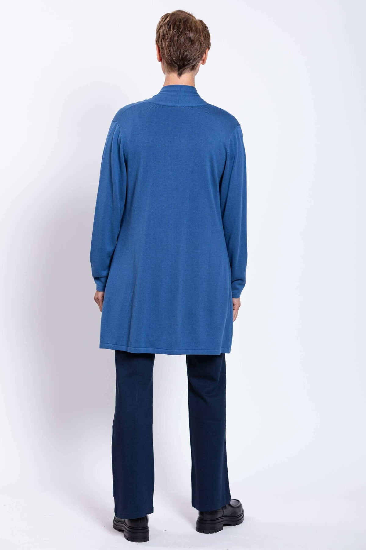 Back view of a woman in a blue cardigan and navy pants