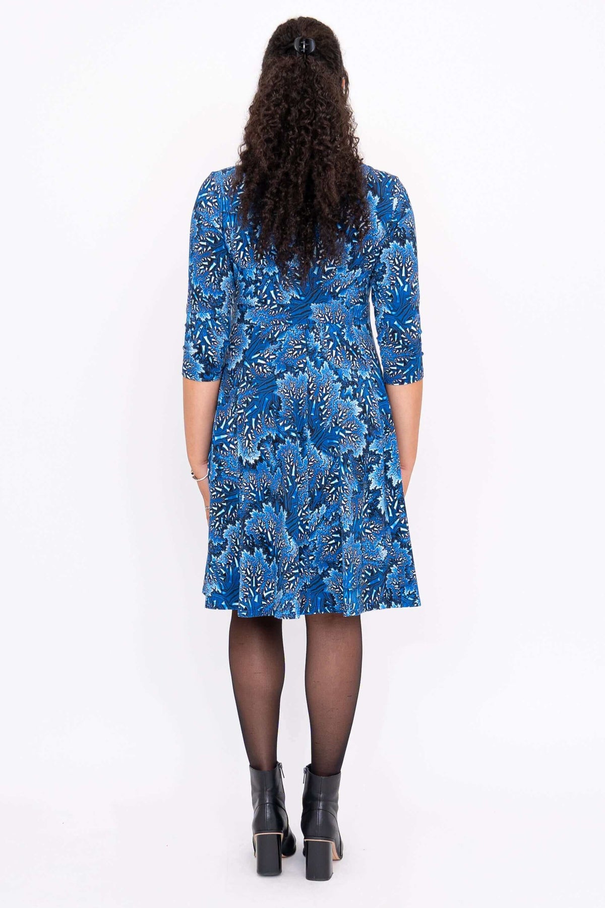 Back view of model wearing blue floral fit and flare dress