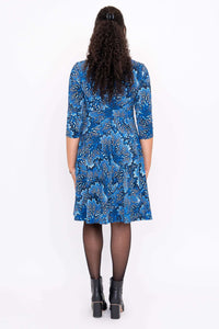 Back view of model wearing blue floral fit and flare dress