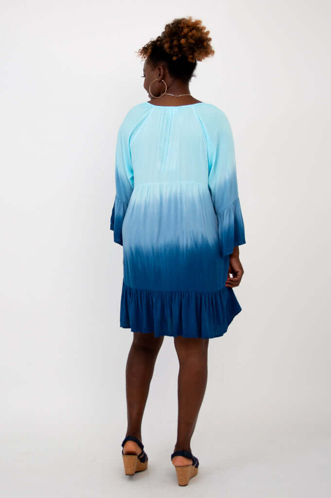 Back view of a model wearing the blue ombre Ellie Dress with flounce hem and ruffle sleeves
