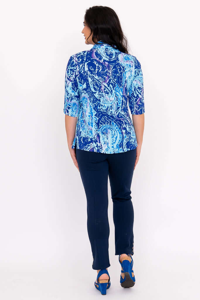 Back view of a woman modeling a blue patterned blouse with a shirt collar