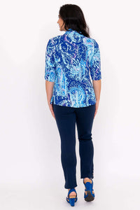 Back view of a woman modeling a blue patterned blouse with a shirt collar
