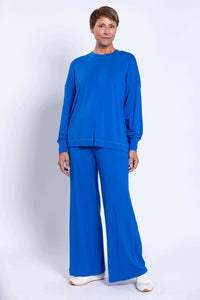 Back view of the woman wearing the same blue relaxed fit crew neck and wide-leg pants