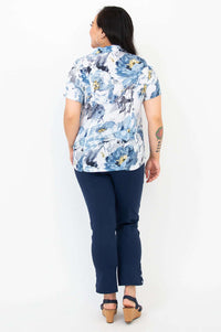 Back view of blue watercolor floral shirt on woman paired with navy pants