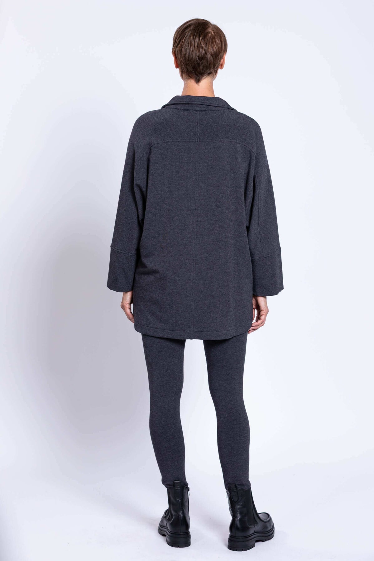 Back view of woman wearing charcoal Taran Jacket with relaxed fit and long sleeves