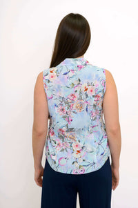 Back view of woman wearing a light blue sleeveless floral button-down shirt
